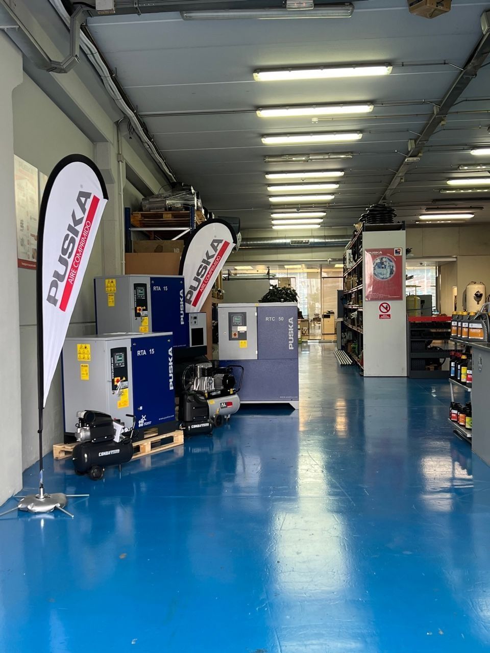 Un almacén con suelo azul y mucha maquinaria.