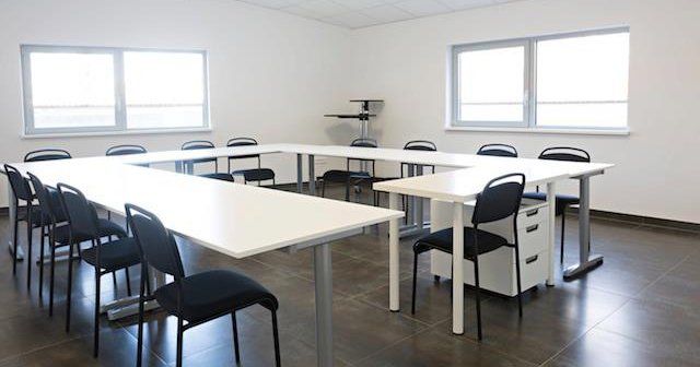 Grande salle de réunion avec tables blanches