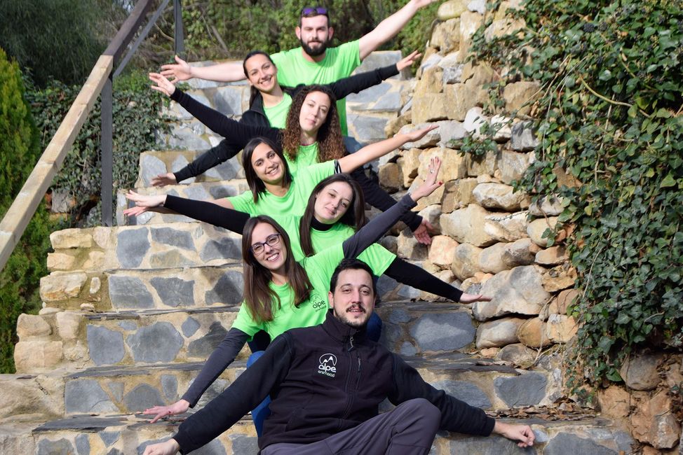 Un grupo de personas posan para una fotografía en unas escaleras.