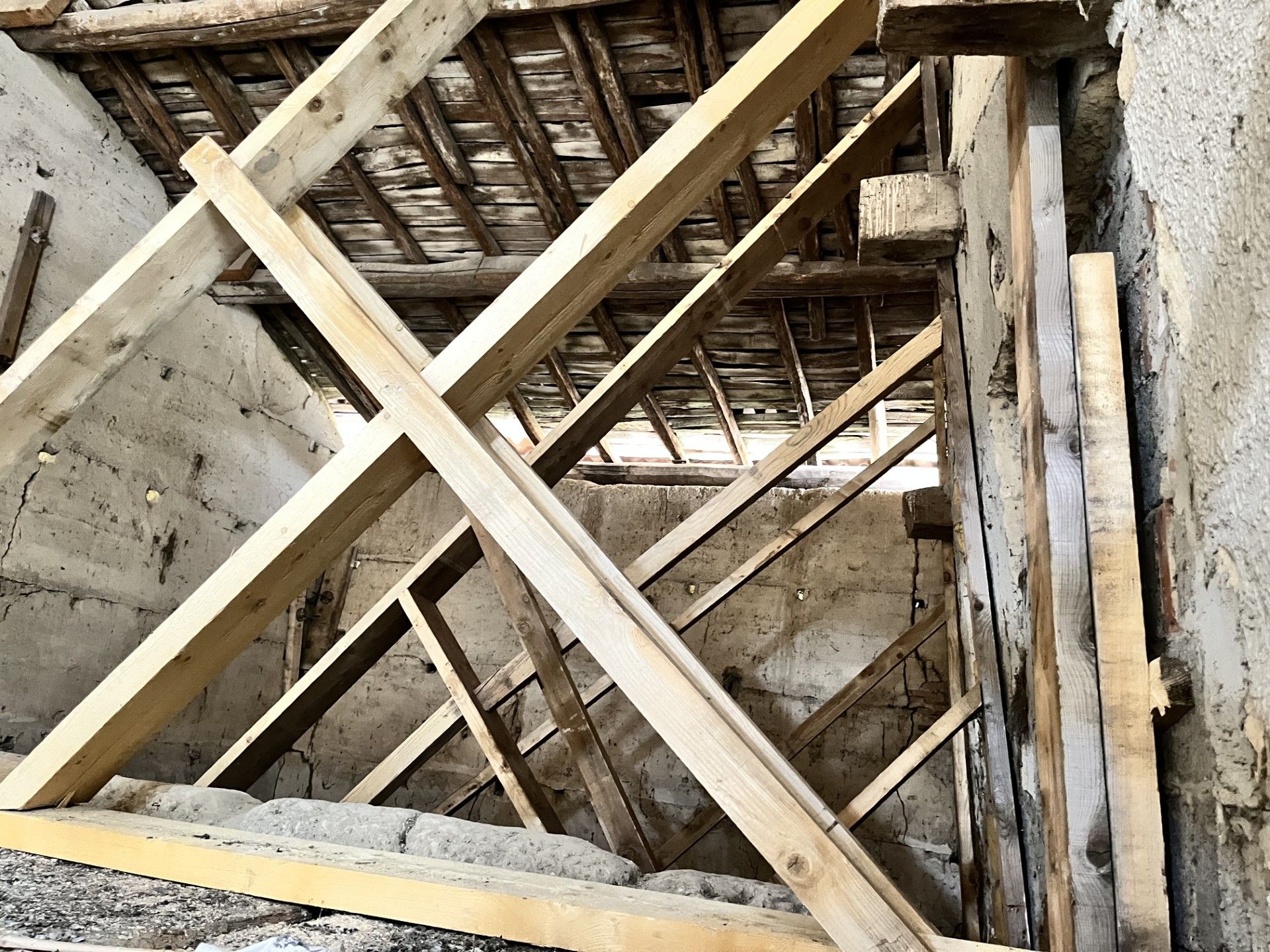 Des poutres neuves qui renforcent une charpente.