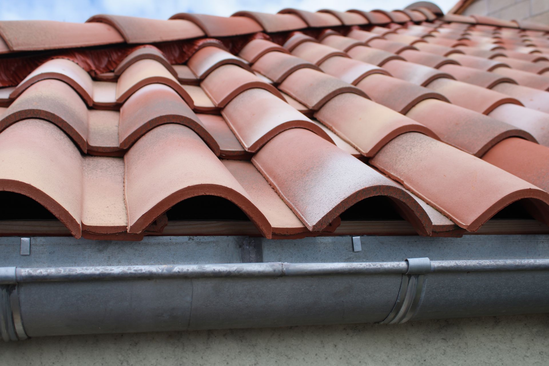Un toit en tuiles avec une gouttière.