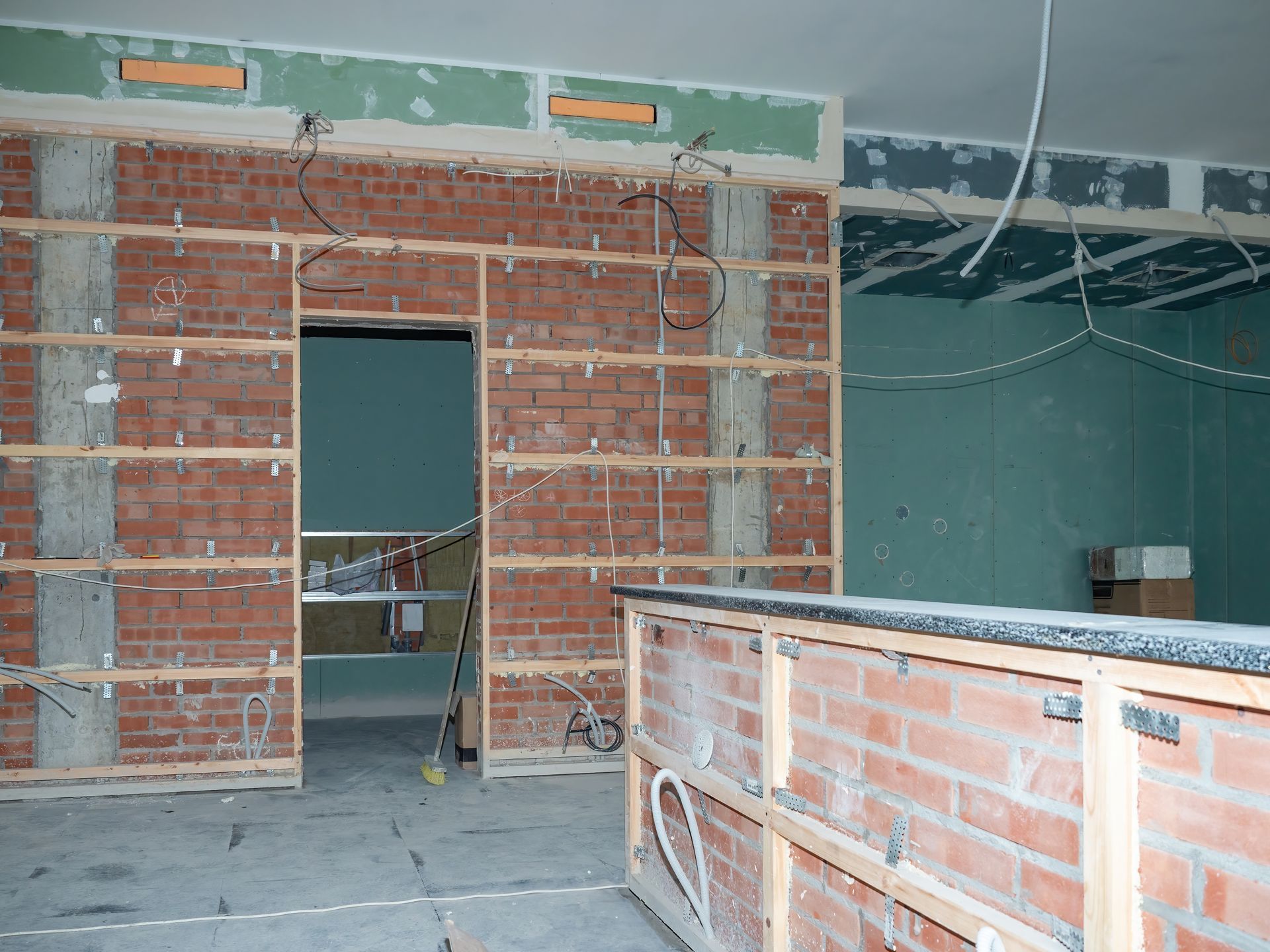 Rénovation intérieure de murs en briques, avec un réseau de câbles électriques autour.