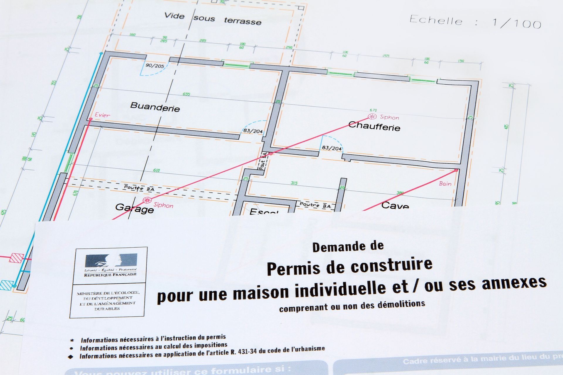 Document de permis de construire avec un plan de maison en arrière-plan.