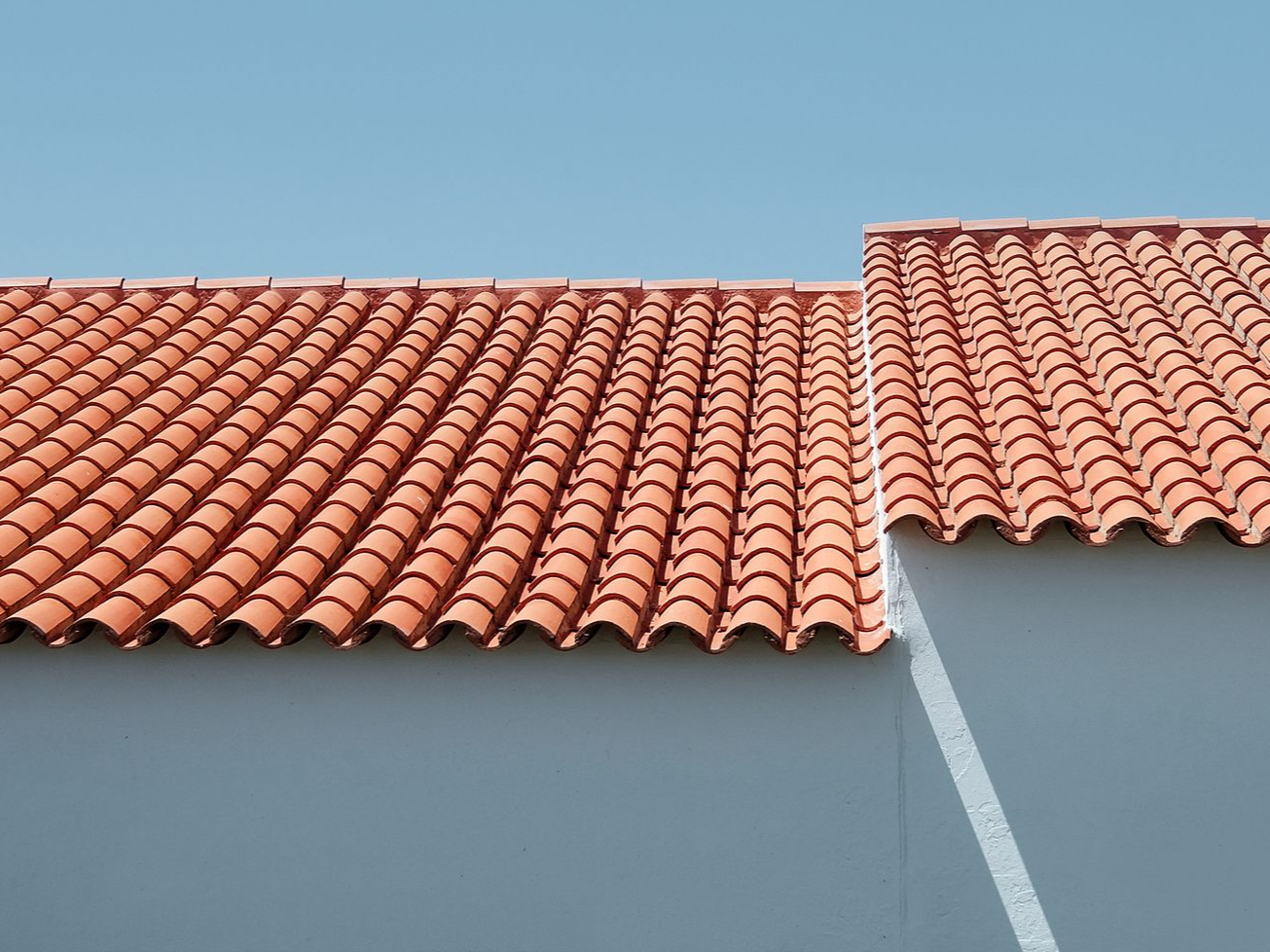 Toit de tuiles rouges avec un ciel bleu en arrière-plan.
