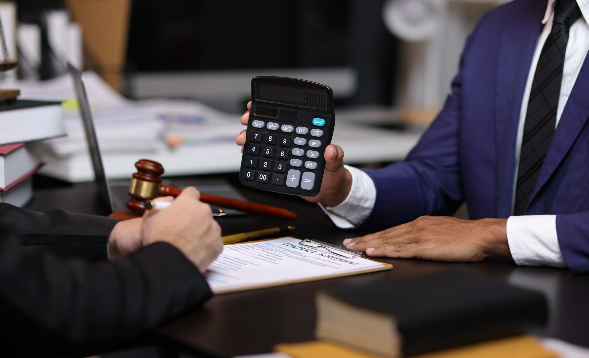 Des hommes d'affaires examinent leurs finances avec une calculatrice.