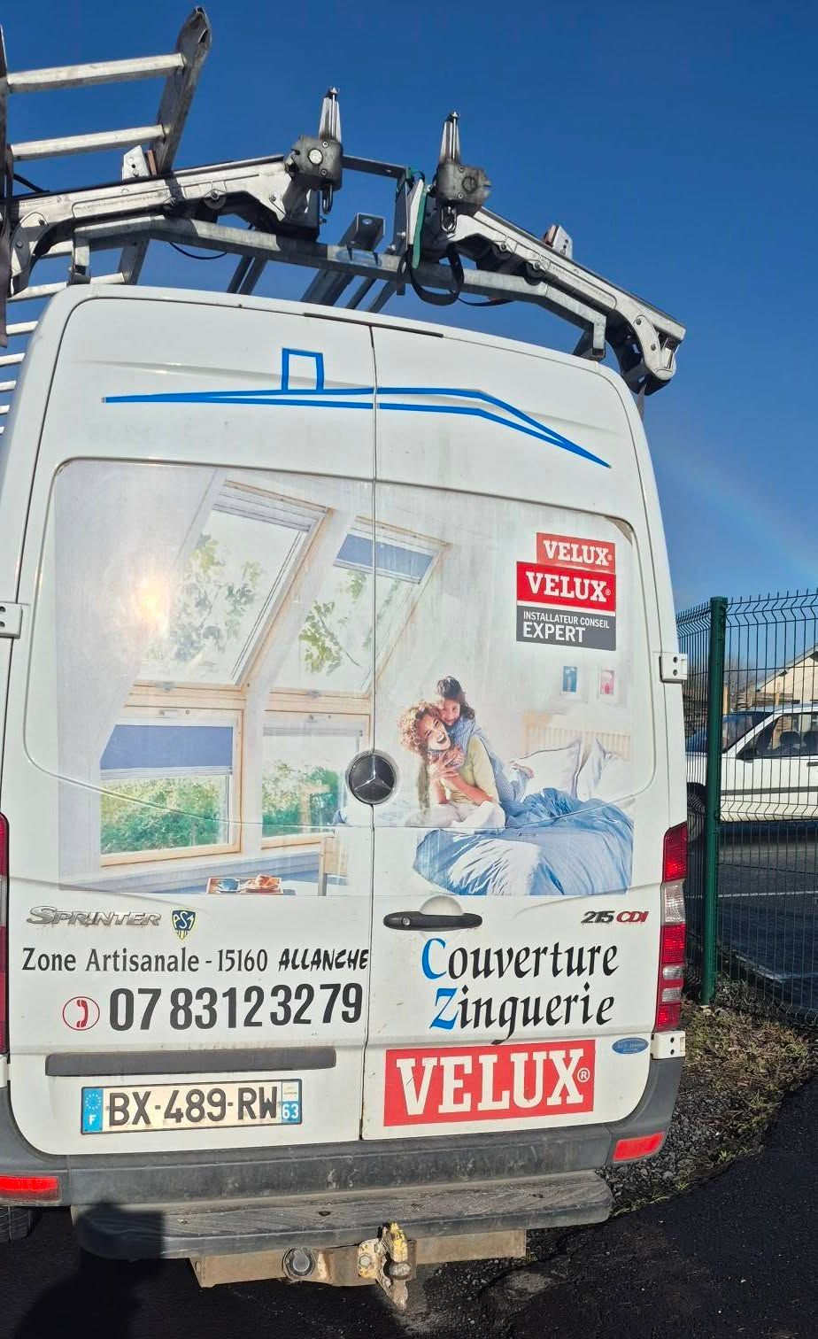 Fourgonnette blanche avec un porte-échelle.