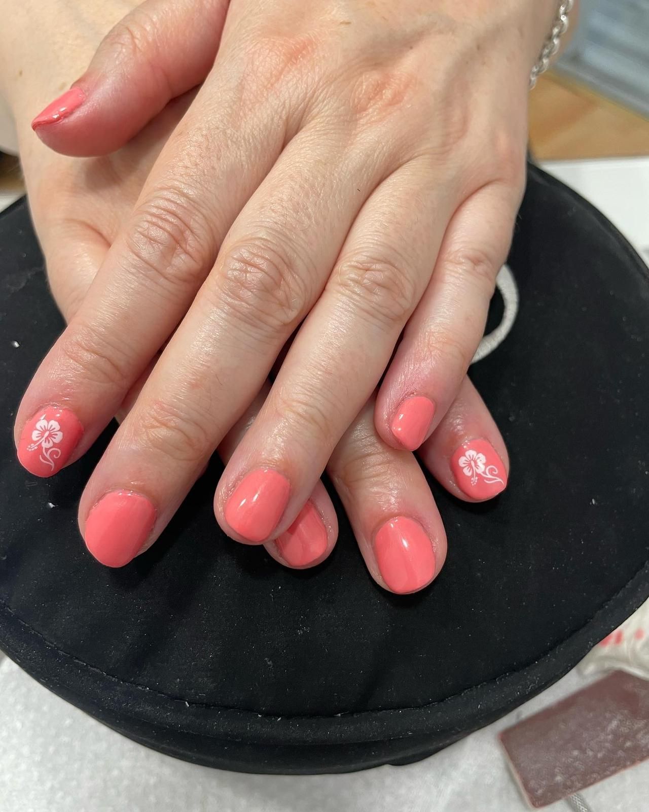 Un primer plano de las uñas de una mujer con esmalte de uñas rosa.