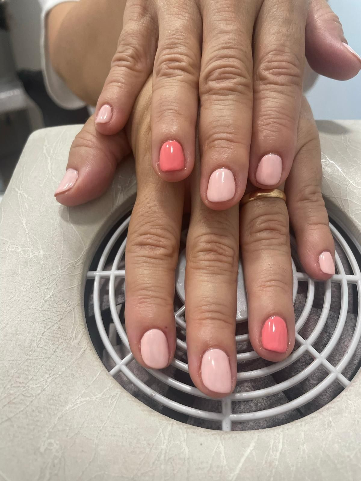 Un primer plano de las manos de una mujer con uñas rosas.