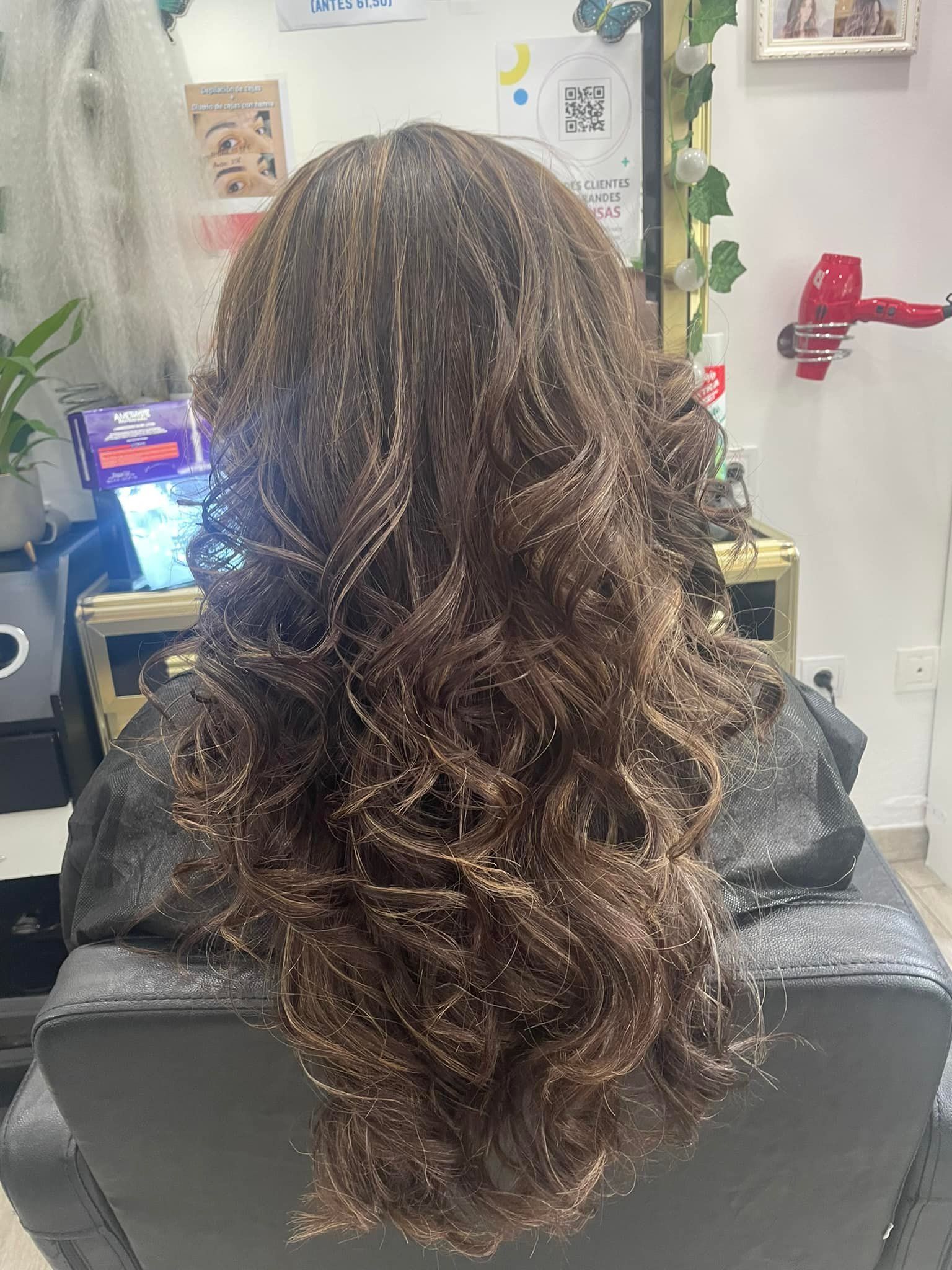 Una mujer está sentada en una silla con su cabello en un salón.