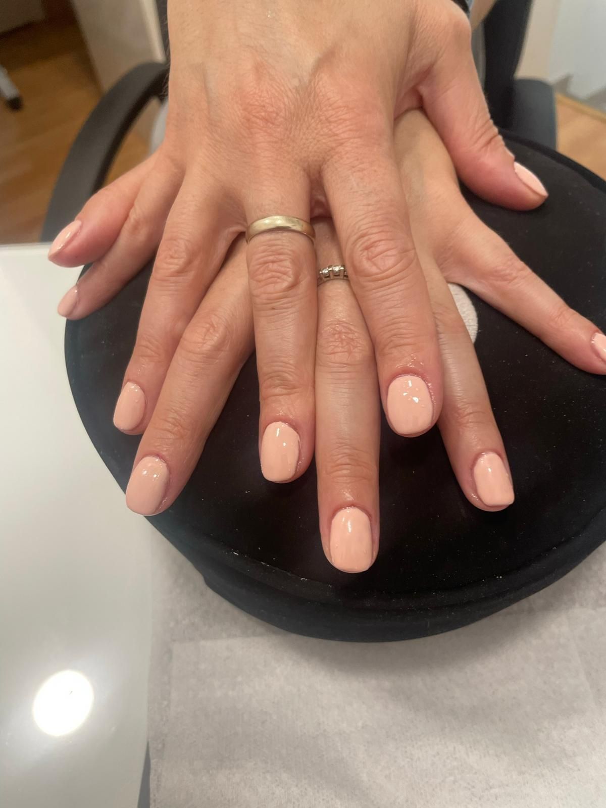 Un primer plano de las manos de una mujer con uñas rosas.