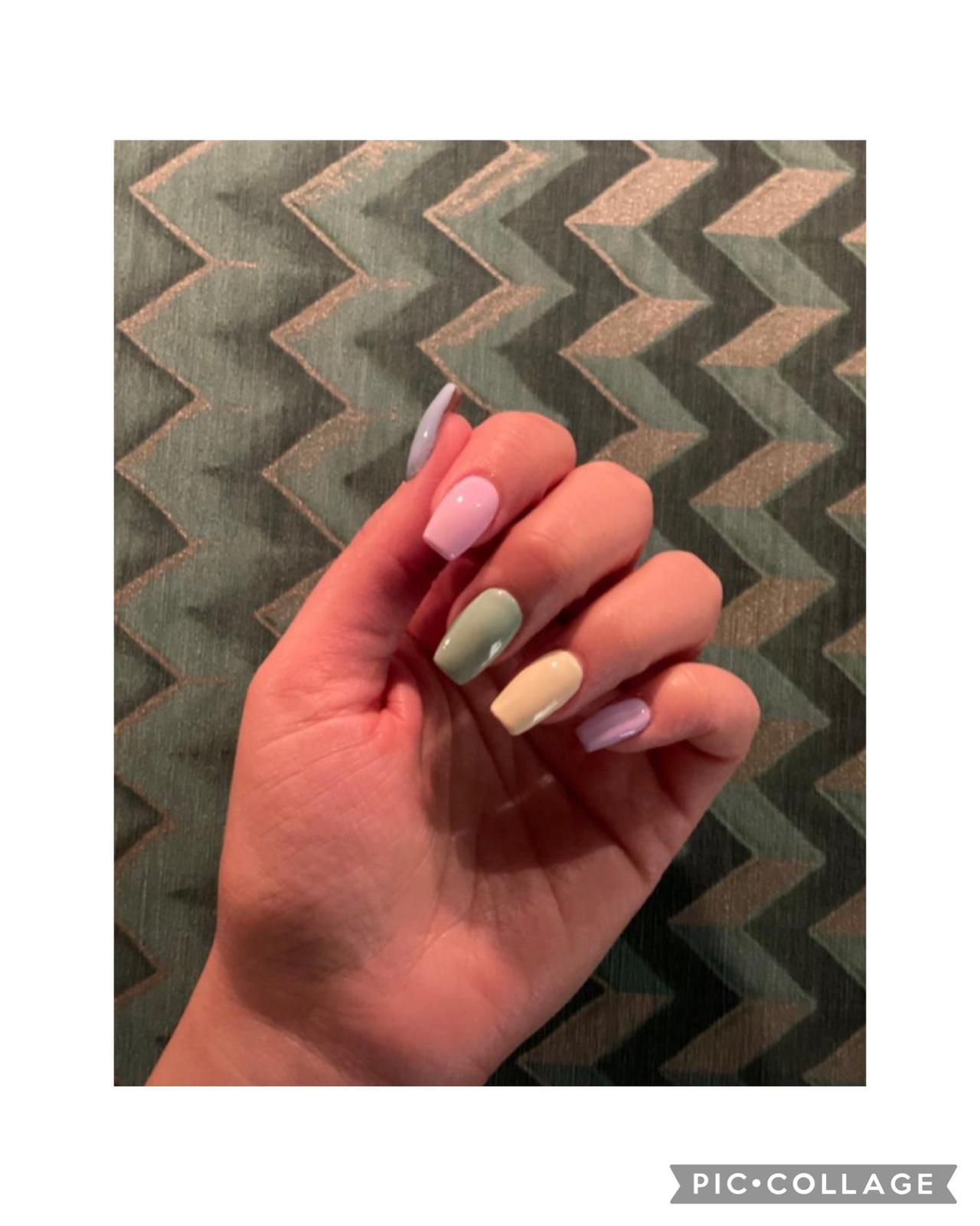 Un primer plano de la mano de una persona con uñas de colores.