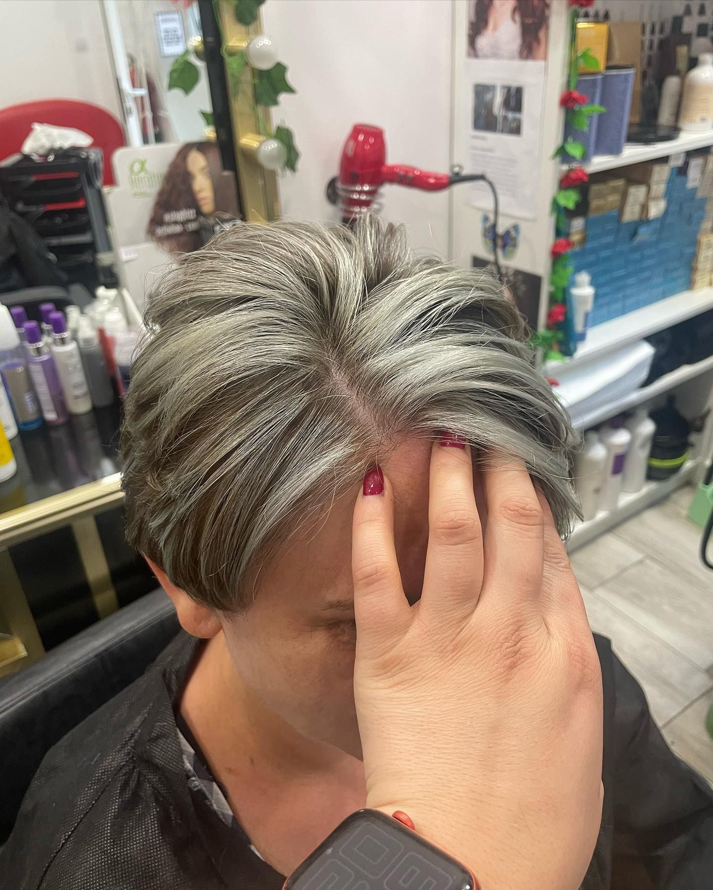 Una mujer se tiñe el pelo en un salón.