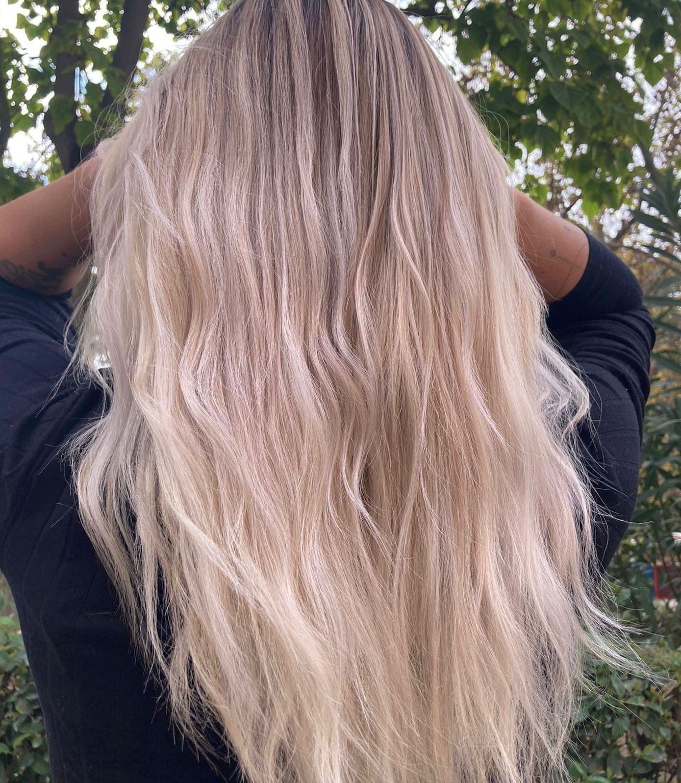 Una mujer con cabello largo y rubio lleva una camisa negra.