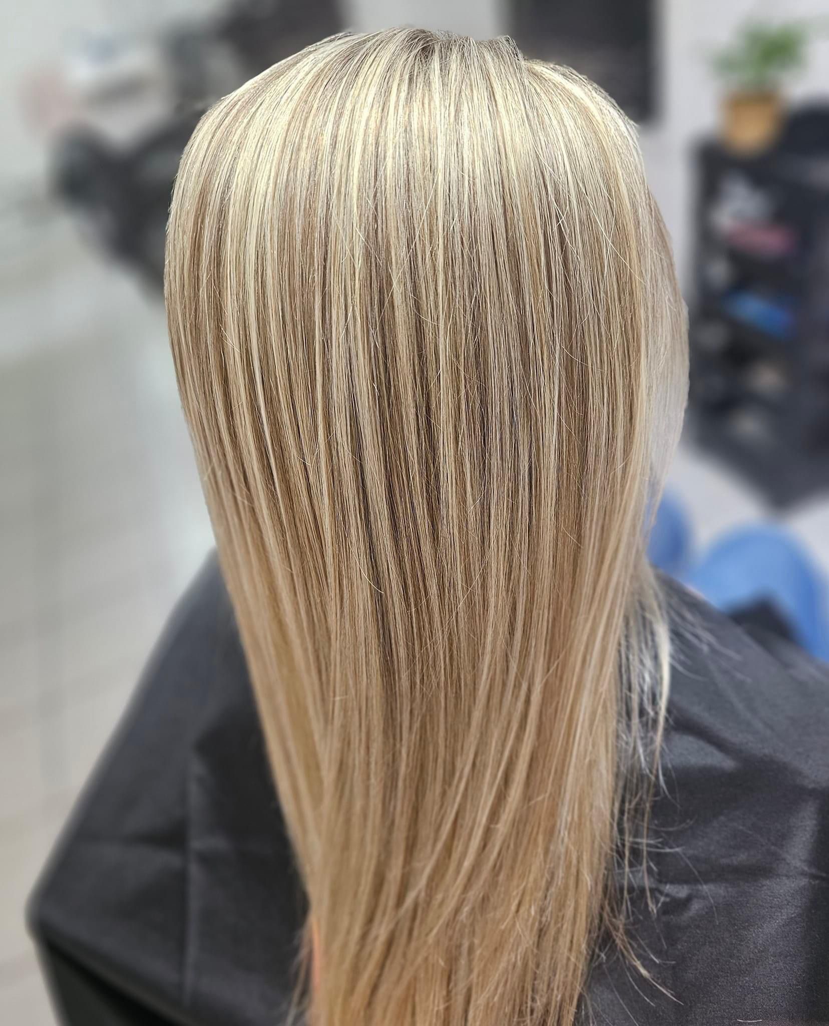 Una mujer se está trenzando el cabello en un salón.
