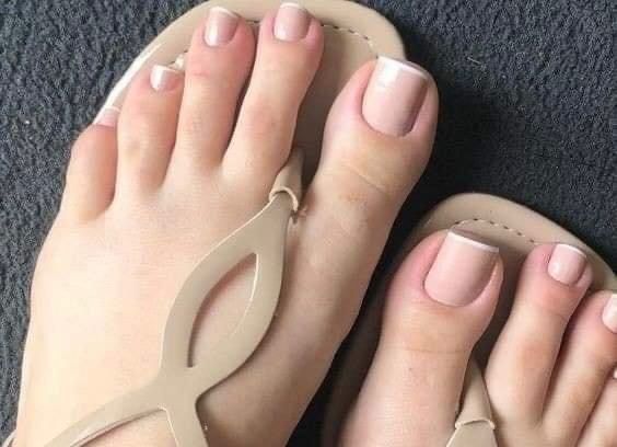 Un primer plano de los pies de una mujer con sandalias.