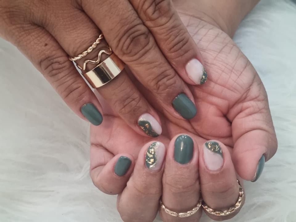 Un primer plano de las uñas de una mujer con anillos en ellas.