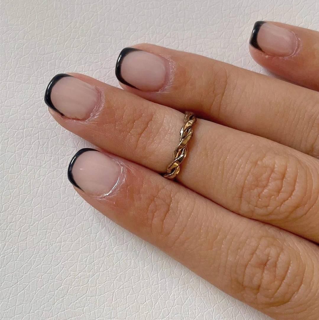 Un primer plano de la mano de una mujer con un anillo en el dedo.