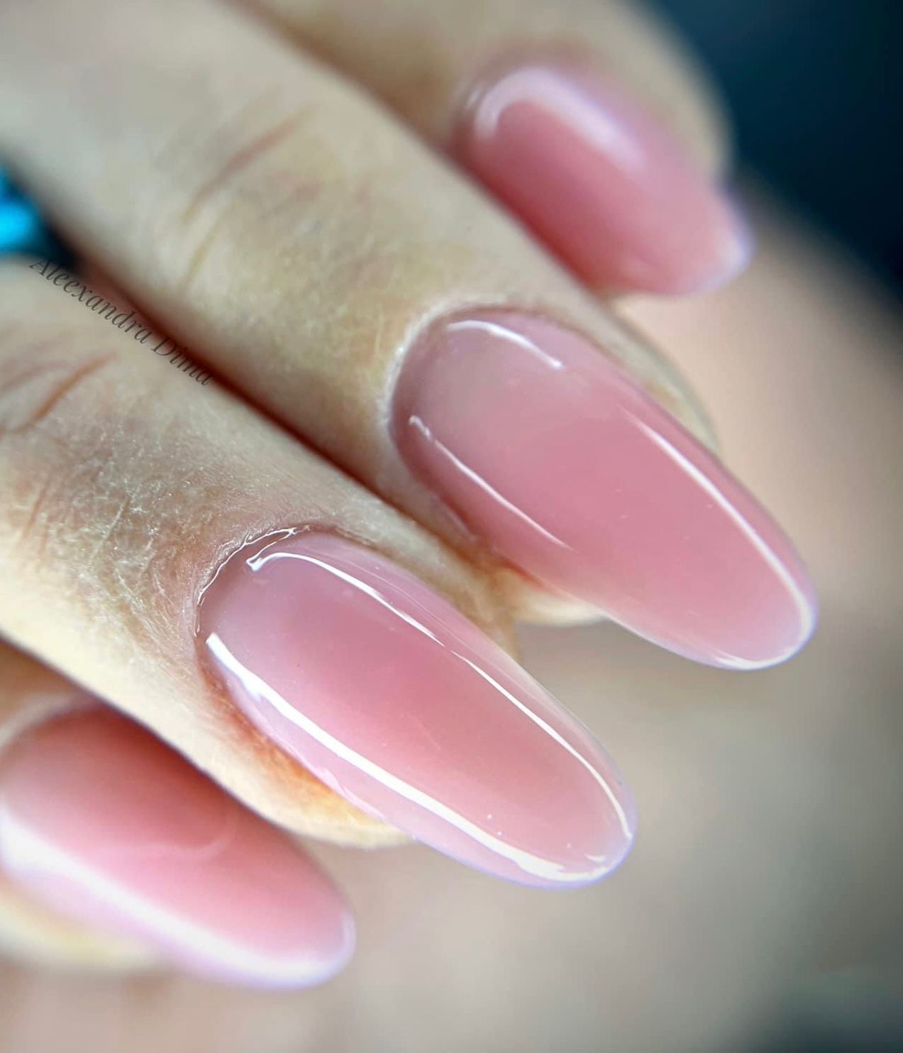 Un primer plano de las uñas de una mujer con esmalte de uñas rosa.