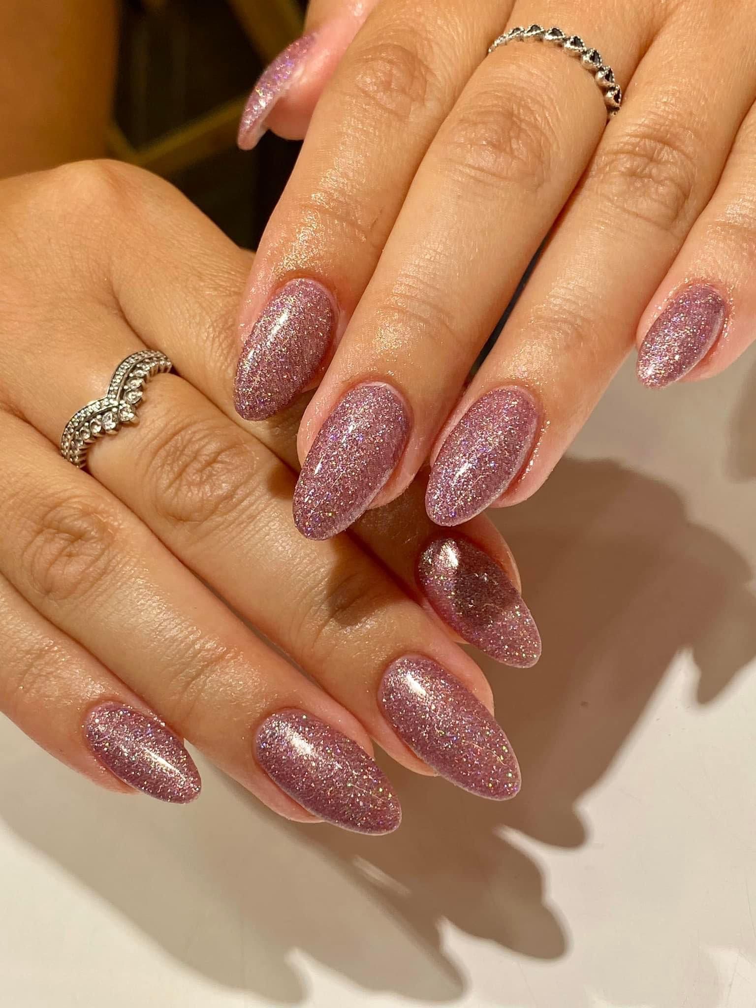 Un primer plano de las uñas de una mujer con un anillo en el dedo.