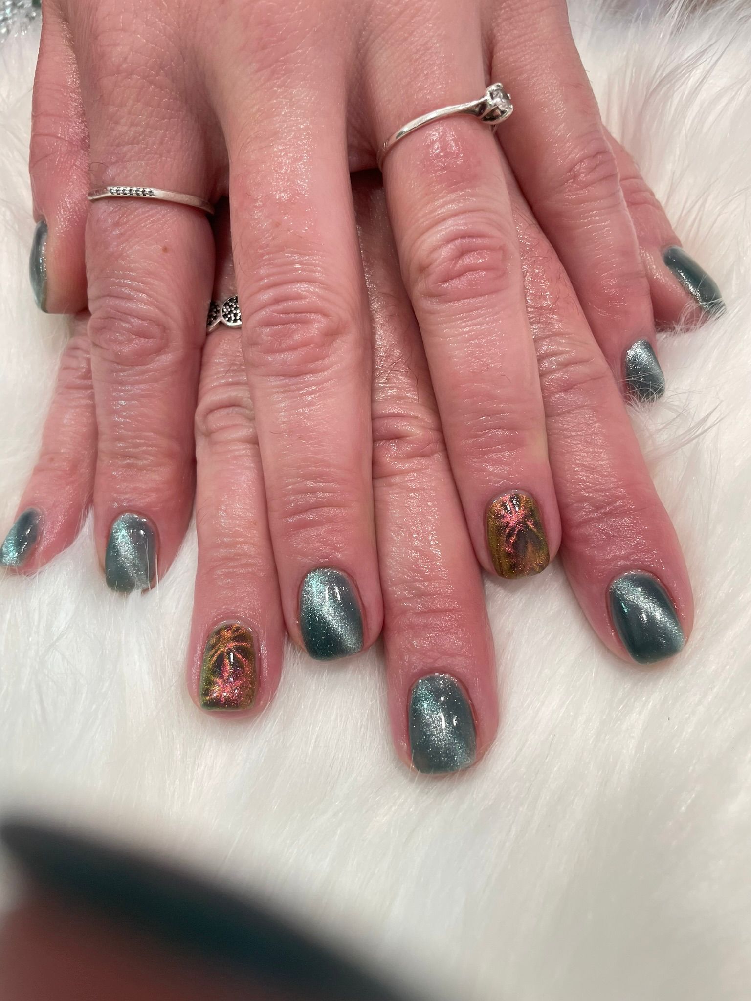 Un primer plano de las uñas de una mujer con un anillo en el dedo.