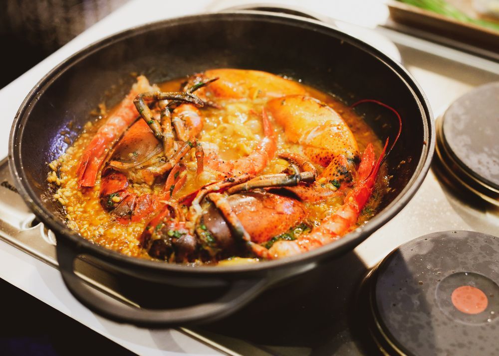 Una sartén llena de camarones y arroz se cocina en una estufa.