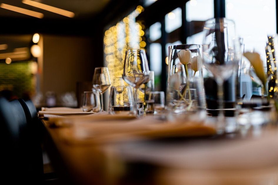 Una mesa preparada para una cena con copas de vino y una jarra encima.