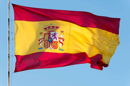 Una bandera española ondea en el viento contra un cielo azul