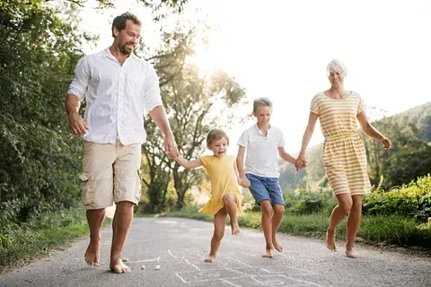 Una familia camina por una calle tomados de la mano.
