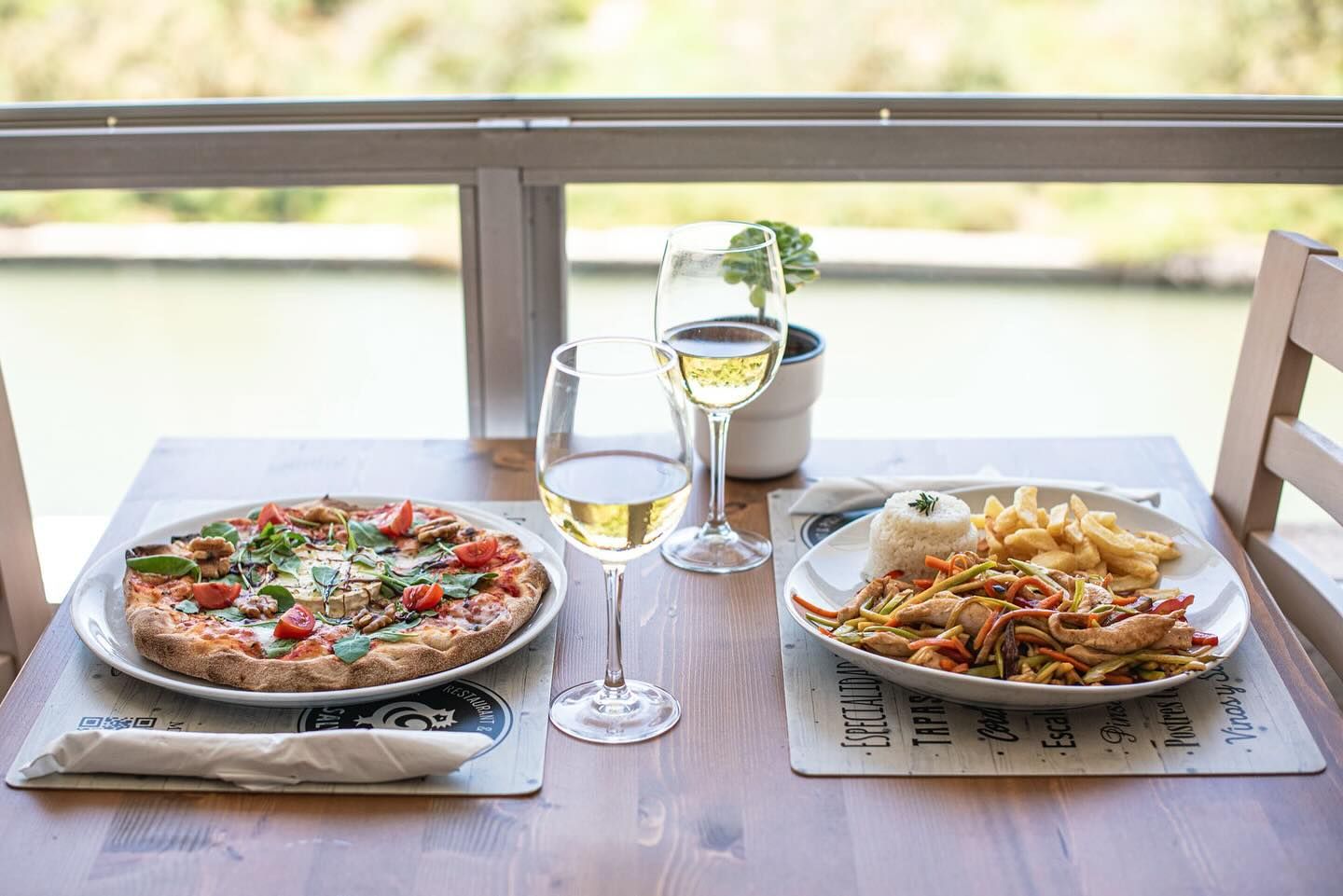 Hay una pizza y un plato de comida en la mesa.