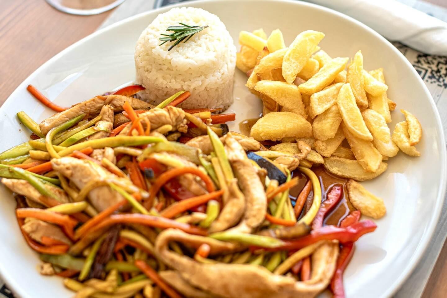 Un plato de comida con arroz y papas fritas en una mesa.