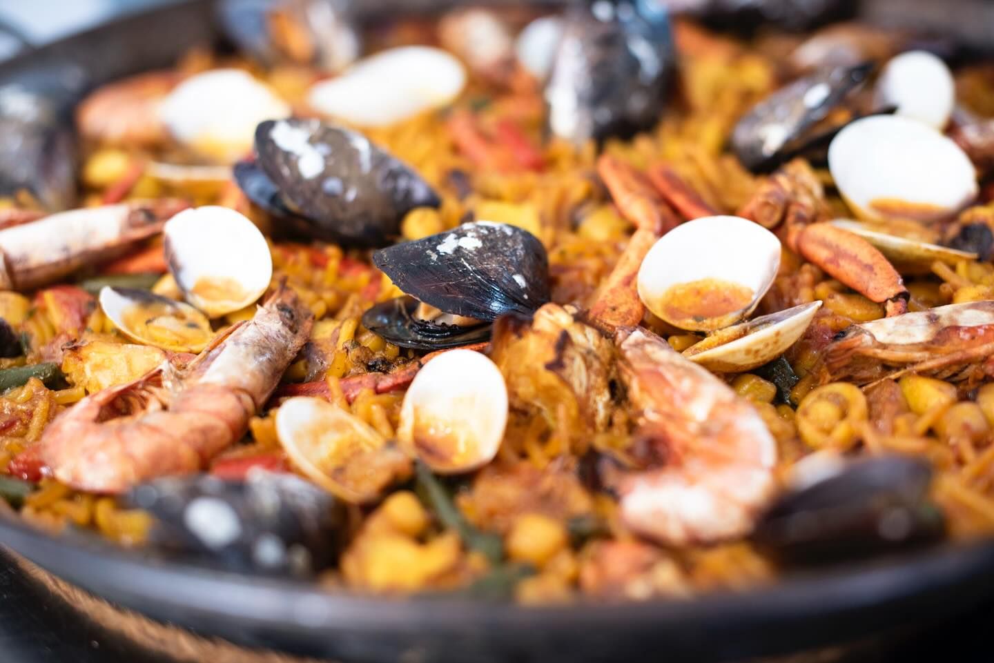 Un primer plano de una paella con camarones, mejillones y huevos en una sartén.