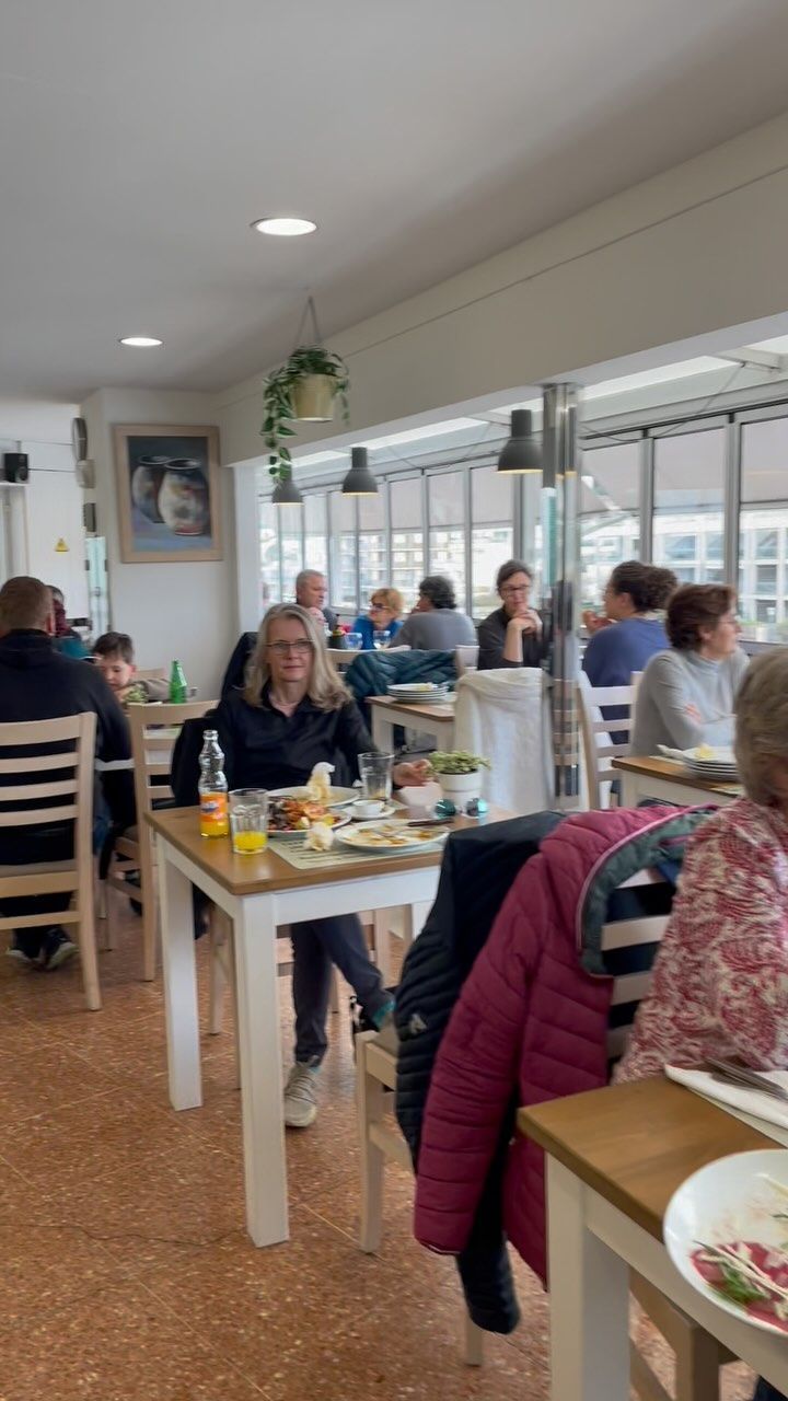 Un grupo de personas están sentadas en mesas en un restaurante.
