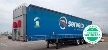Un camión semirremolque azul con la palabra Serveto en él.