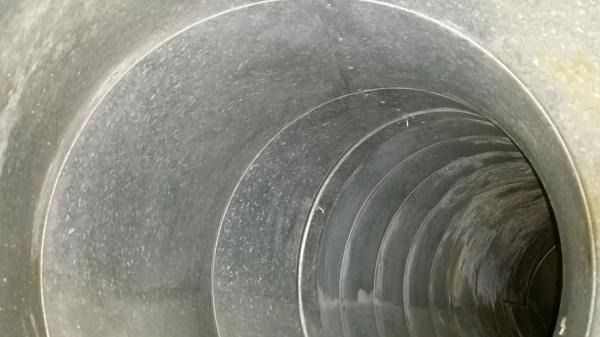 Un primer plano de una tubería de metal que pasa por un túnel.