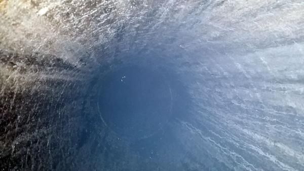 Un primer plano de una cascada con un cielo azul de fondo.