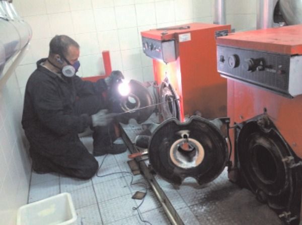 Un hombre que lleva una máscara está trabajando en una máquina.