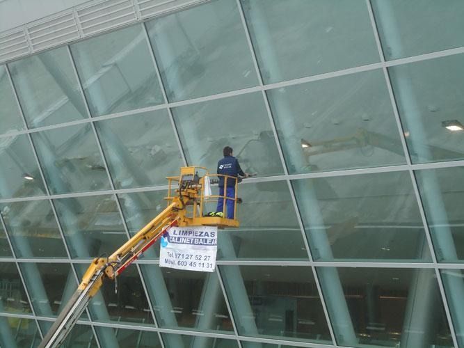 Un hombre está limpiando las ventanas de un edificio.