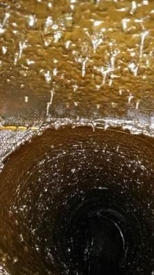 Un primer plano de un fregadero del que sale agua.