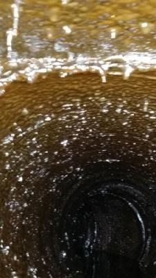 Un primer plano de un desagüe con agua saliendo de él.