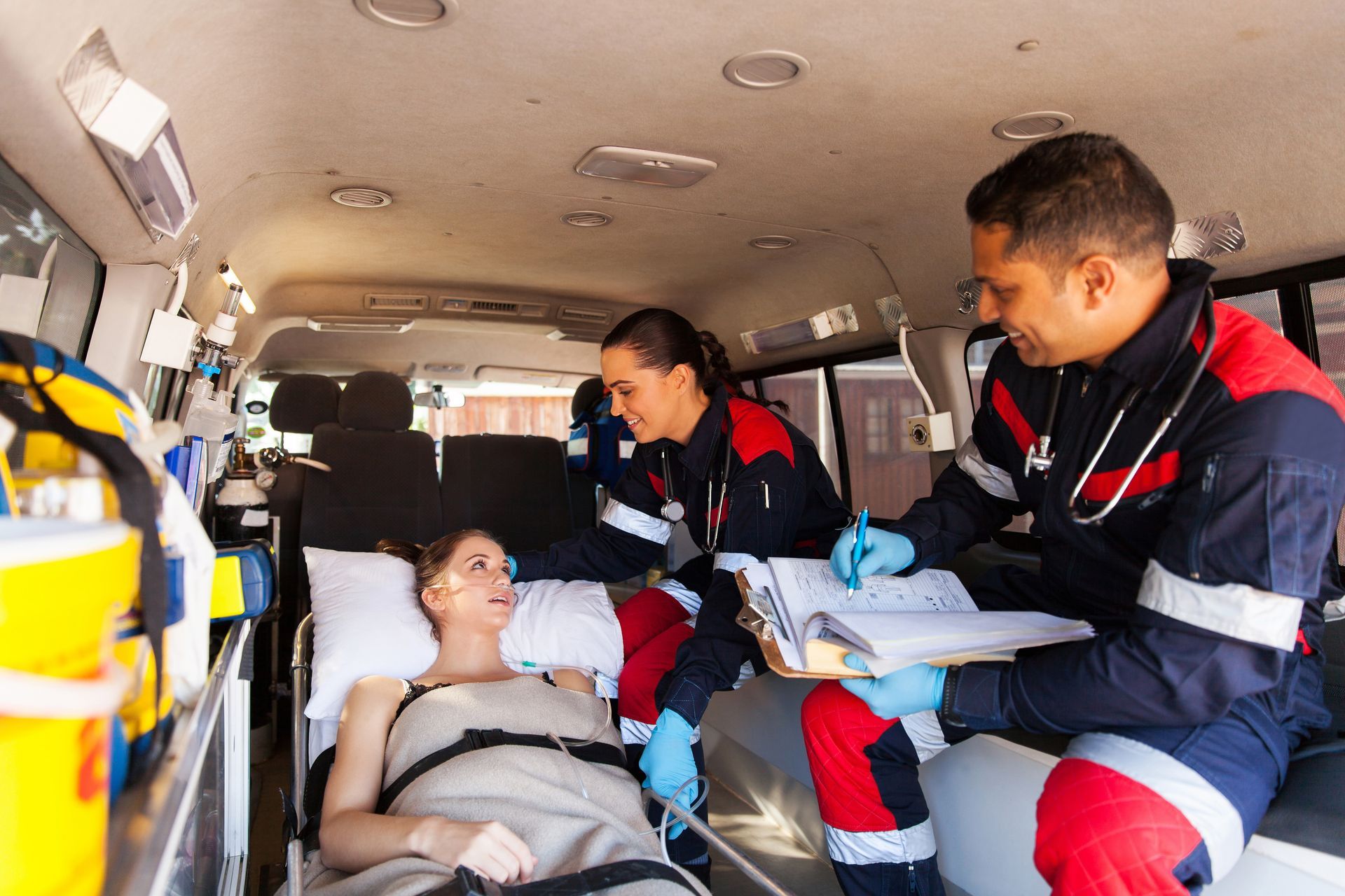 Femme allongées avec deux ambulanciers dans une ambulance