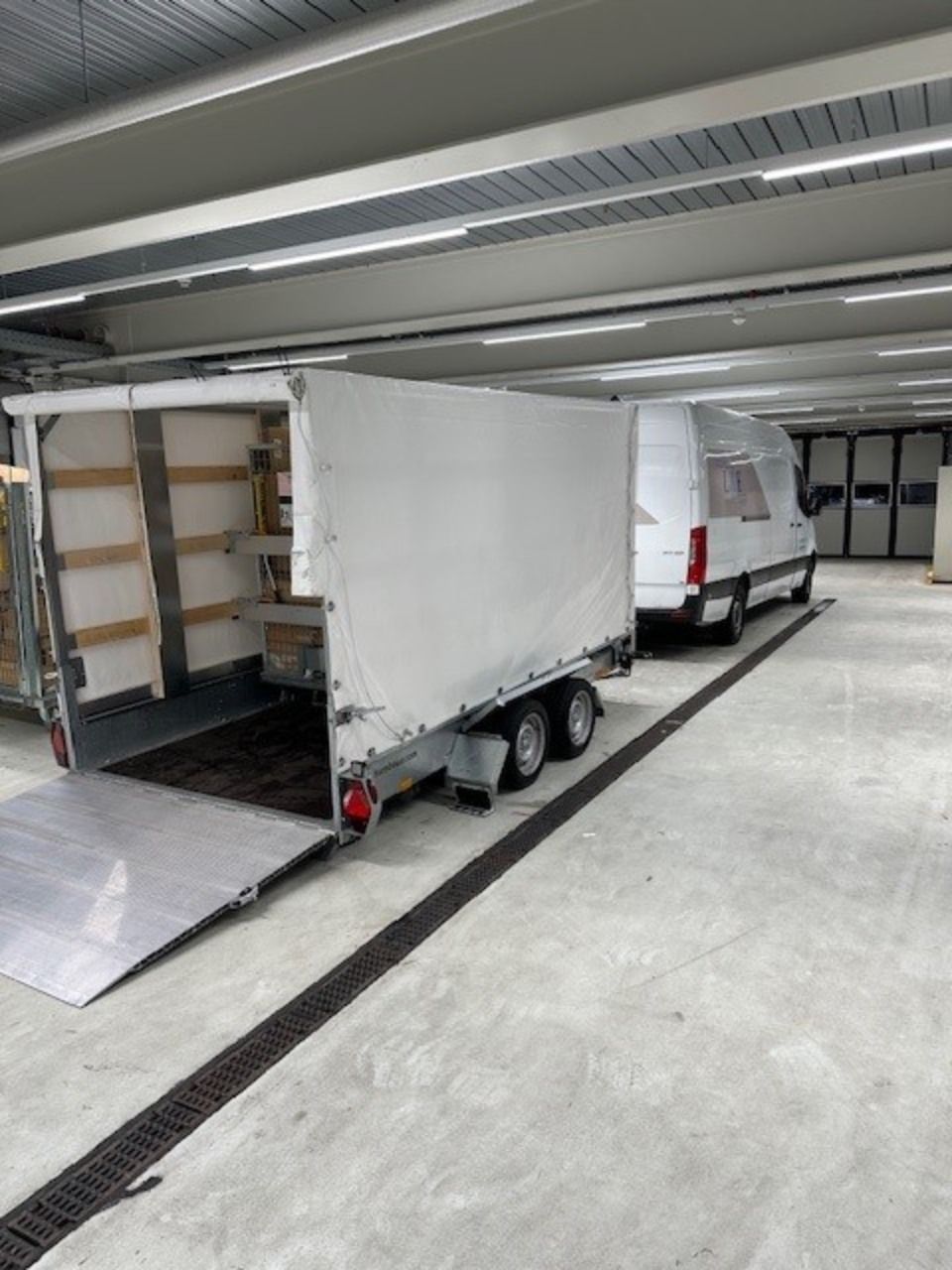 Zwei weisse Lieferwagen stehen nebeneinander in einem Parkhaus. Foto von der L&E Transport und Logistik GmbH