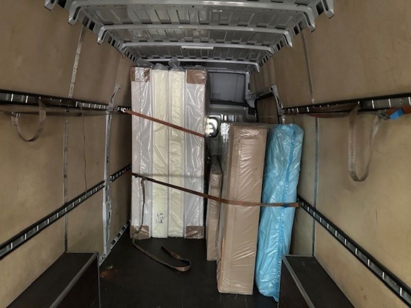 Das Innere eines Lieferwagens voller Kisten und Matratzen. Foto von der L&E Transport und Logistik GmbH