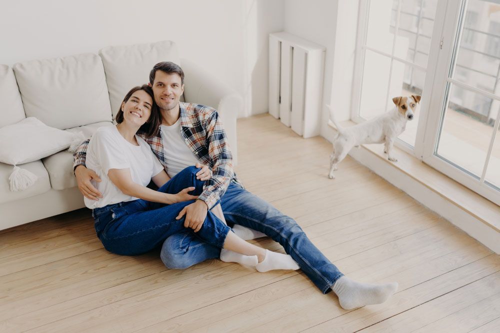 Couple assis sur le sol avec un petit chien
