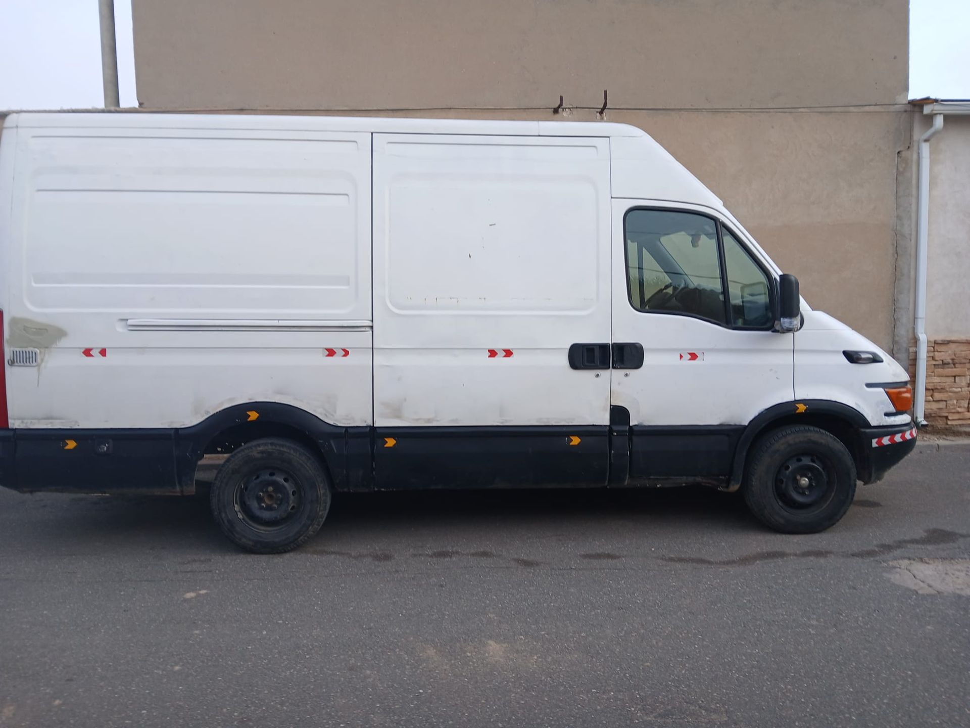 Una camioneta blanca está estacionada frente a un edificio