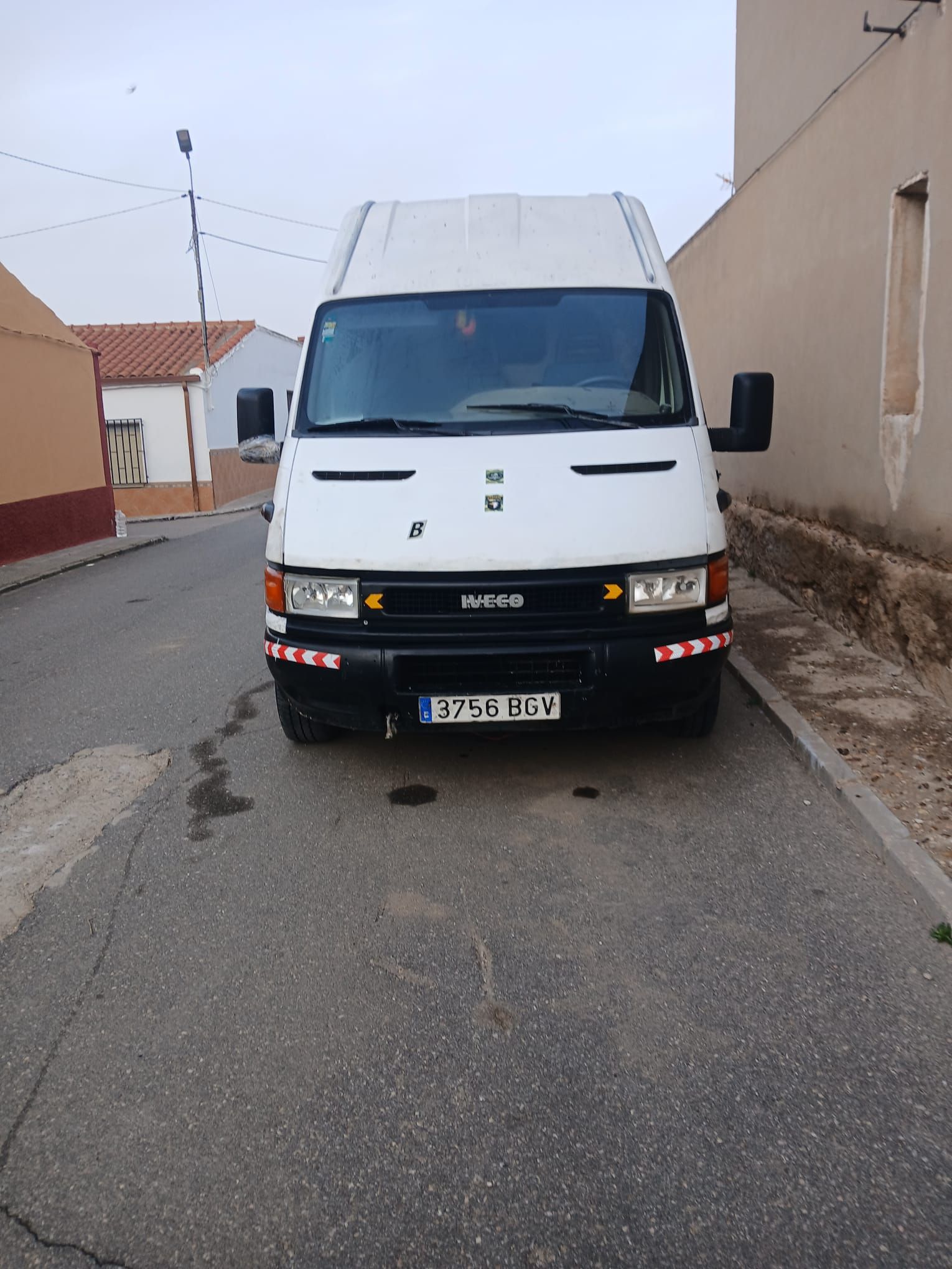 Una camioneta blanca está estacionada al costado de la carretera