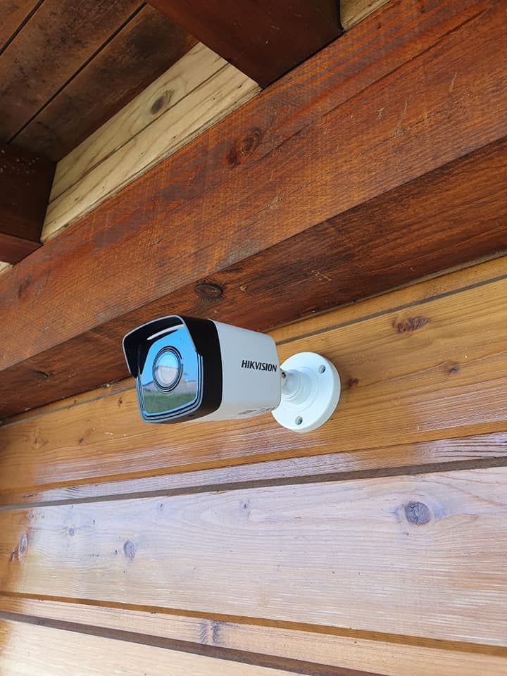 Caméra de sécurité fixée sur le mur en bois d'un bâtiment.