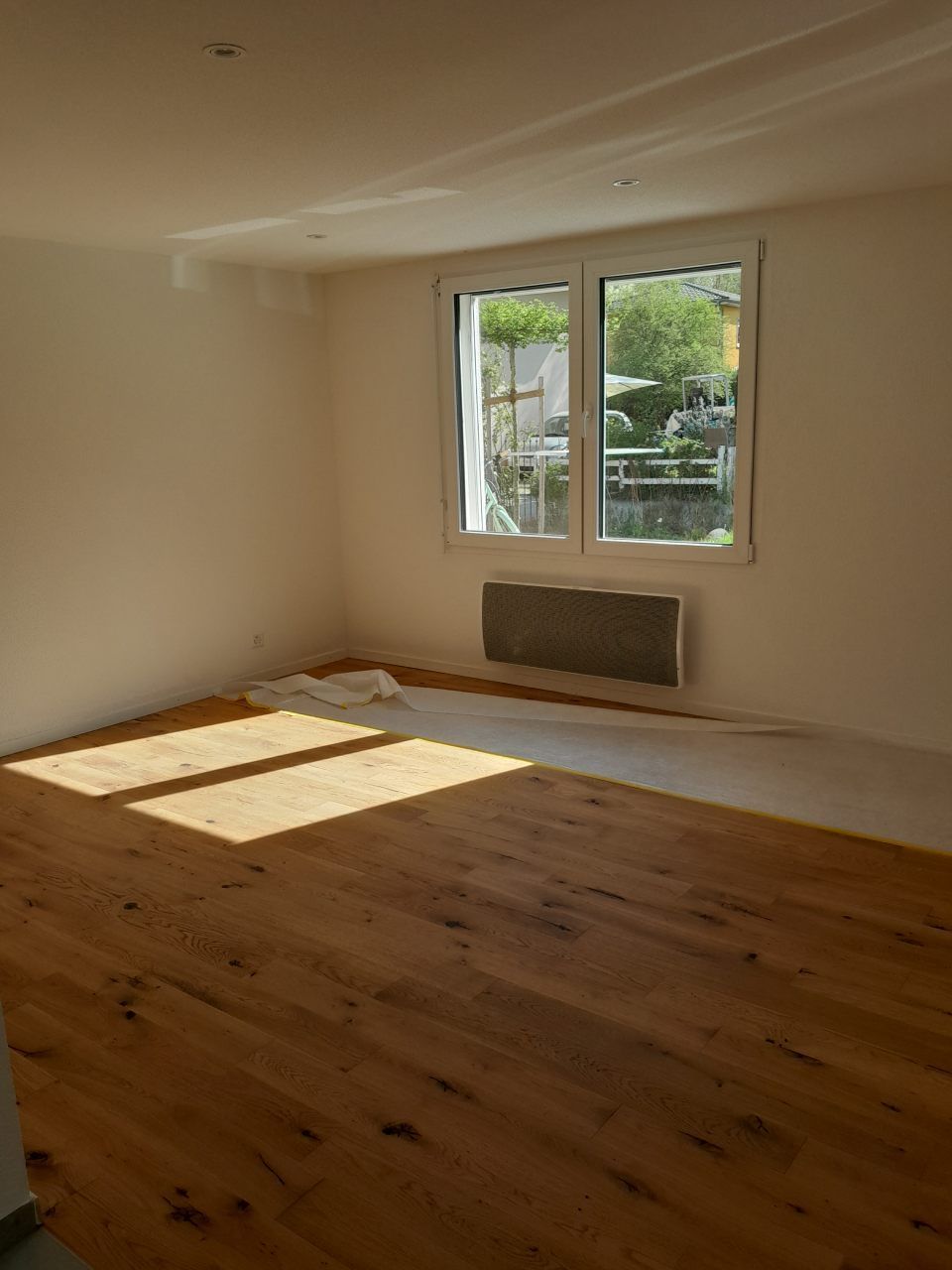 Une pièce vide avec un plancher en bois et une fenêtre