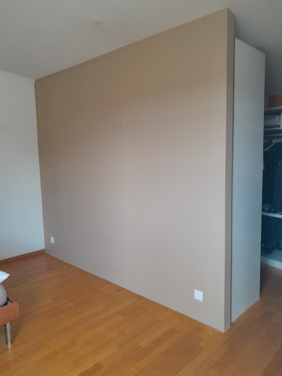 Une pièce avec un grand mur et un plancher en bois