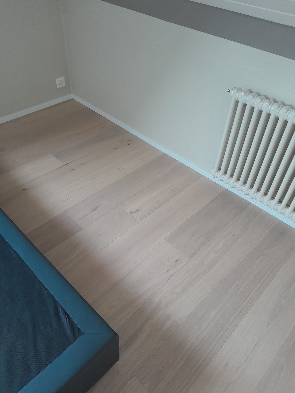 Une chambre avec un lit et un radiateur au sol.