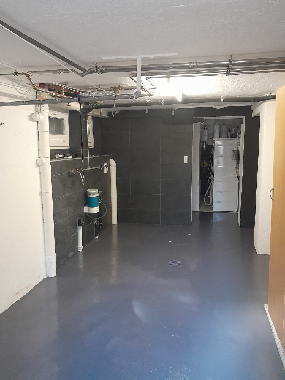 Un sous-sol vide avec un sol bleu et des murs blancs